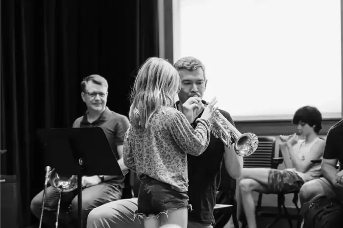 A New York Philharmonic Principal Brass musician with a local student — trading some music tips.