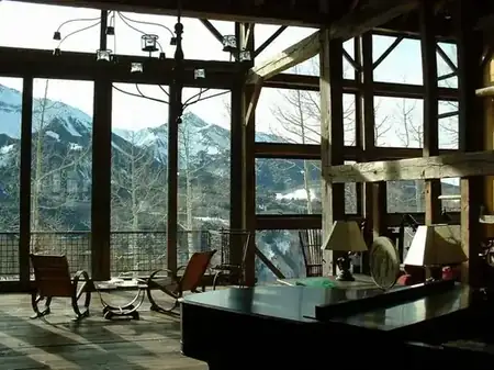 Inside the Mai Home — floor-to-ceiling windows opening onto the snowy mountains