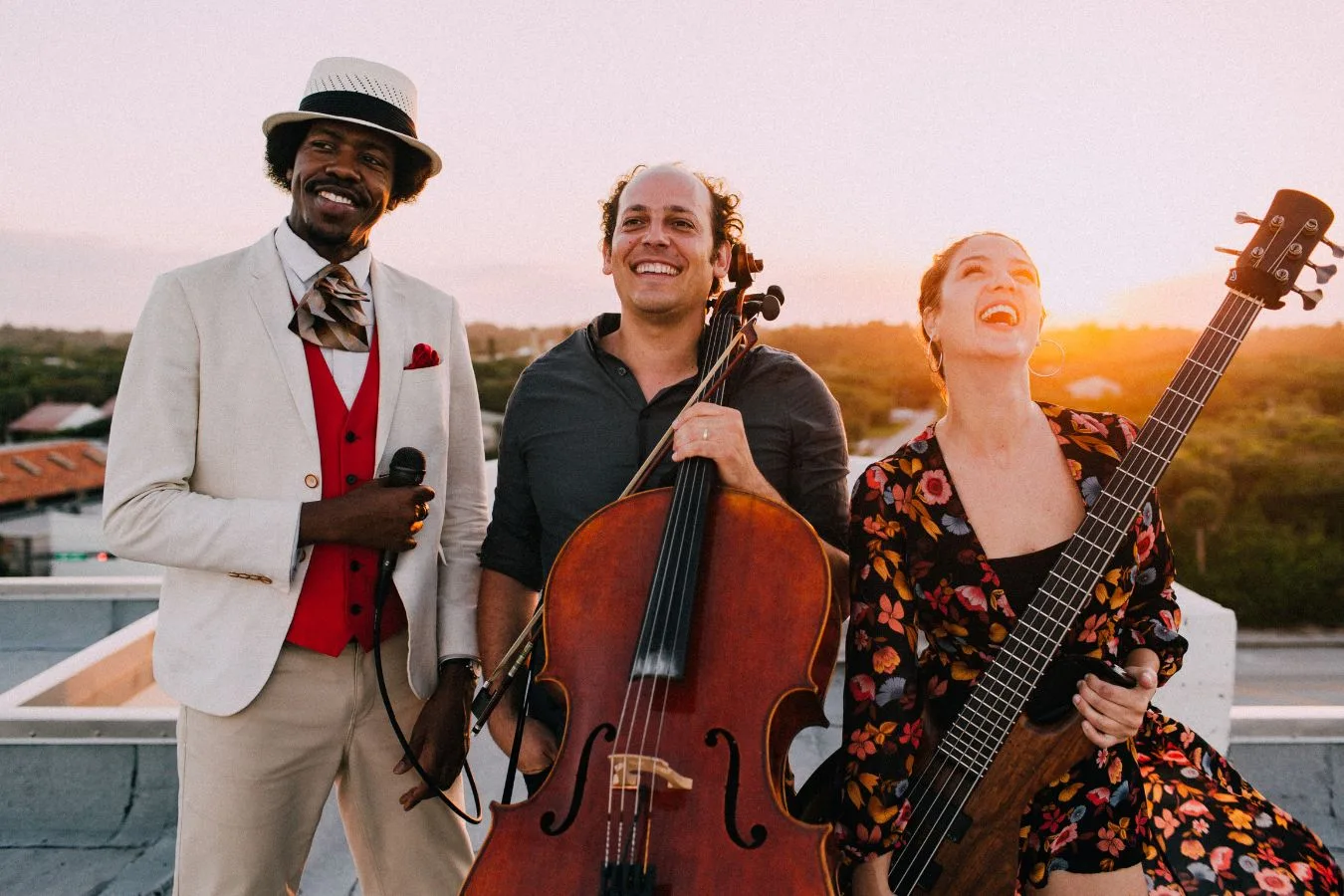 Biriba Union — three musicians laughing on a Telluride rooftop at sunset